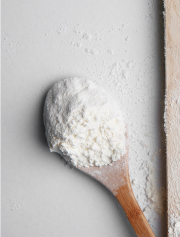 Wooden spoon holding white powder magnesium supplement.
