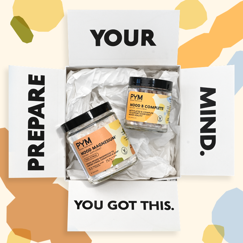 Open box with flaps labeled 'PREPARE YOUR MIND. YOU GOT THIS.' containing two jars of PYM dietary supplements: 'MOOD MAGNESIUM' and 'MOOD B COMPLETE'.