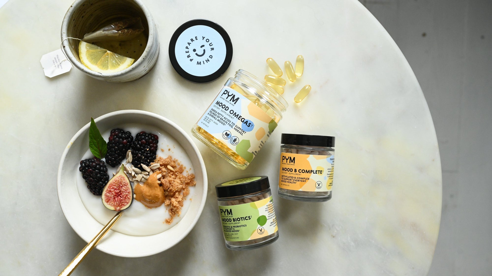 A bowl of yogurt and fruit with B vitamins, omega-3's and probiotics supplements