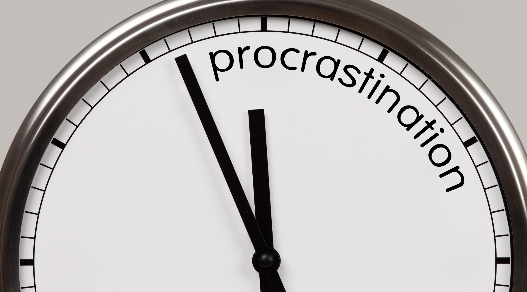 Close-up of a clock face showing the time at 11:55 with the word 'procrastination' curved along the top right edge.