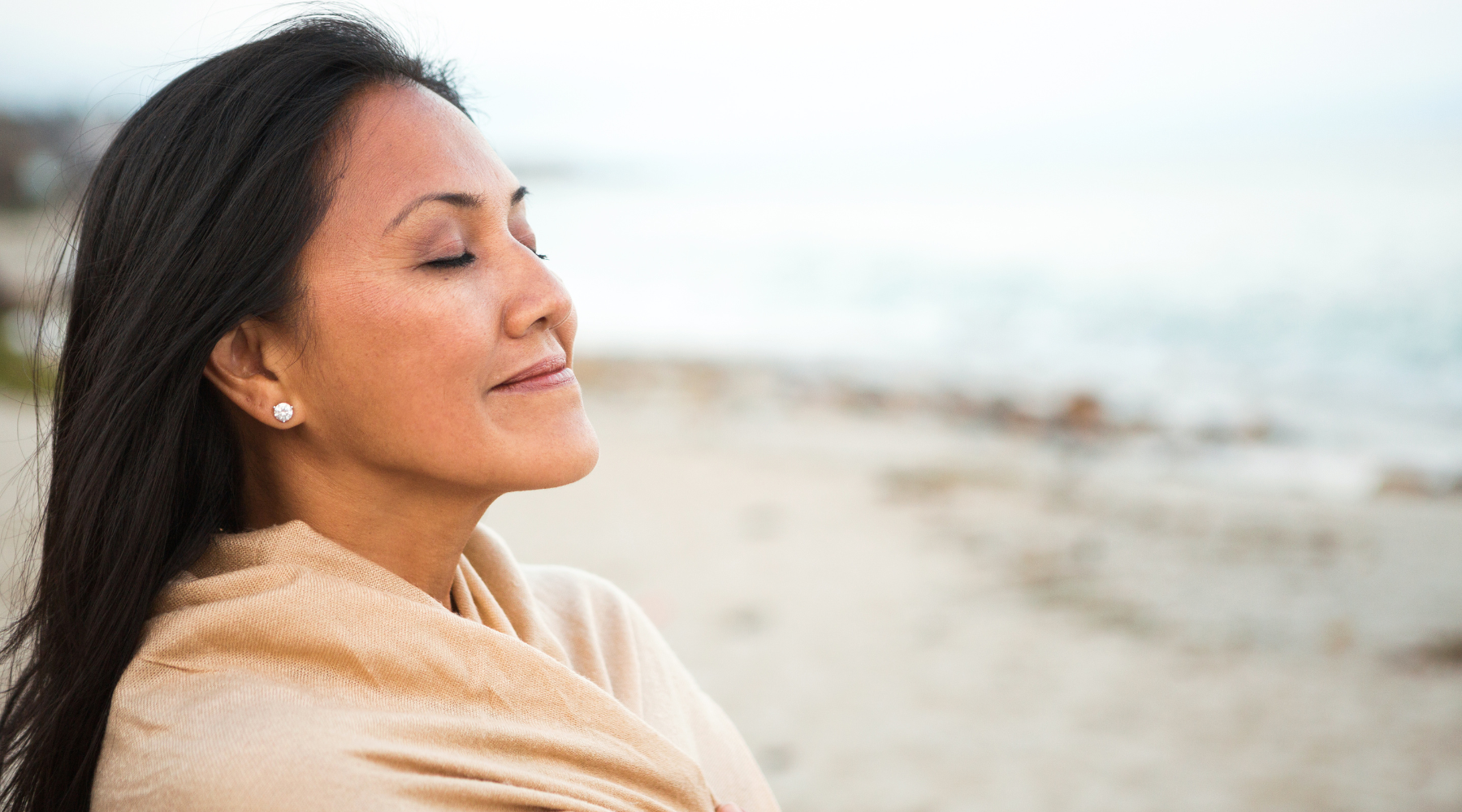 Asian woman with a peaceful smile on the beach