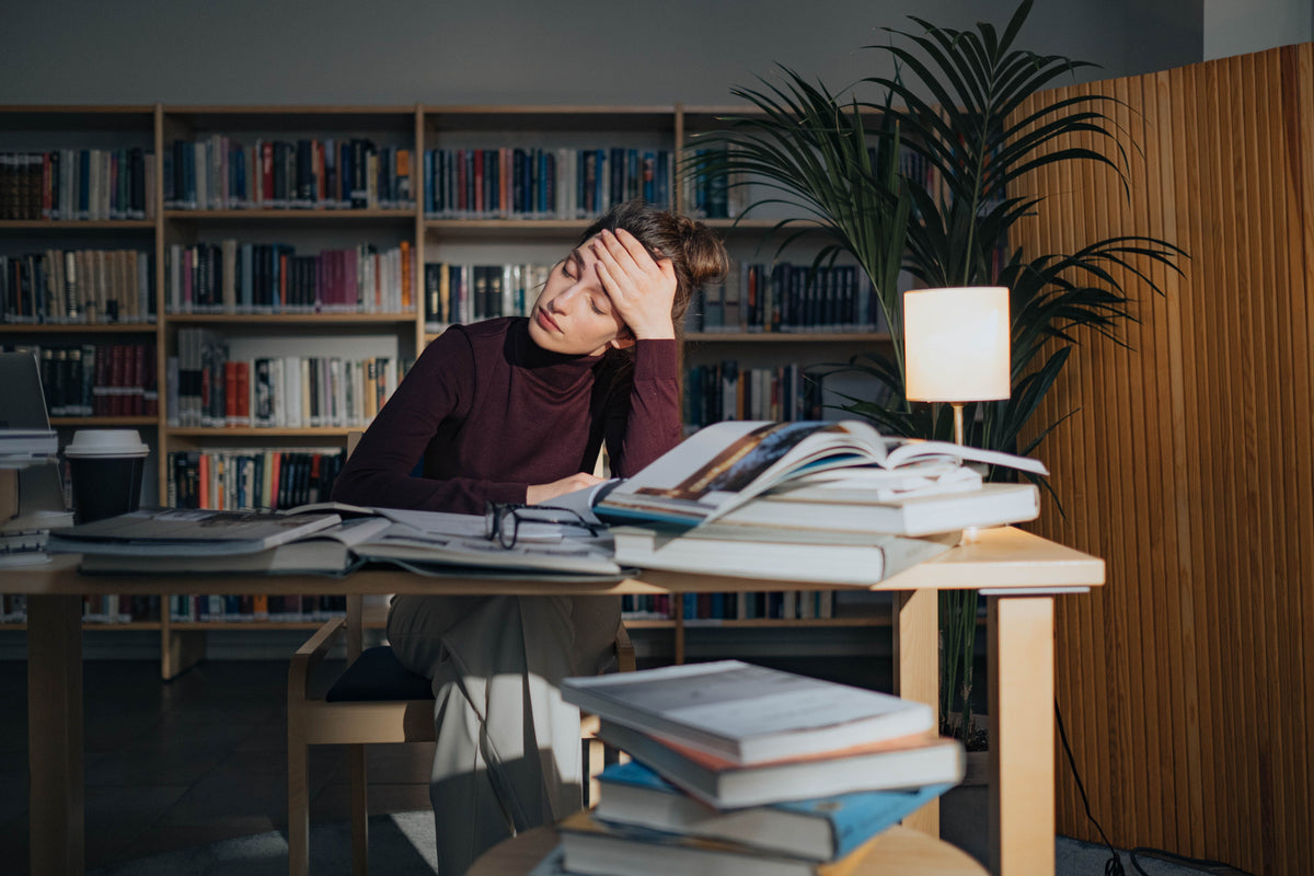Women at desk with hand on forehead
