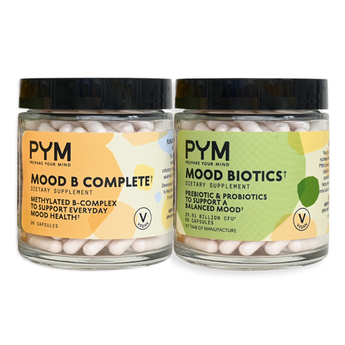 Two jars of dietary supplements from PYM: one labeled 'MOOD B COMPLETE, DIETARY SUPPLEMENT, METHYLATED B-COMPLEX TO SUPPORT EVERYDAY MOOD HEALTH, 30 CAPSULES, VEGAN'; the other labeled 'MOOD BIOTICS, DIETARY SUPPLEMENT, PREBIOTIC & PROBIOTICS TO SUPPORT A BALANCED MOOD, 60 CAPSULES, VEGAN'